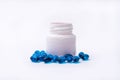 Blue pills and medicine bottle on white background. Royalty Free Stock Photo