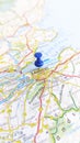 A blue pin stuck in Edinburgh on a map of Scotland portrait