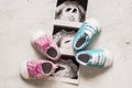 Blue and pink booties next to baby photos with ultrasound in 4th week of pregnancy. Twins. Son and daughter. Selective focus.