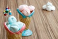 Blue and pink meringue in the pink and blue cones with cupcakes on wood background and white meringues Royalty Free Stock Photo
