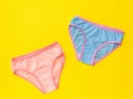 Blue and pink panties on a light yellow background. The concept of meeting lovers. Underwear. The view from the top. Royalty Free Stock Photo