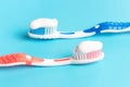 Blue and pink toothbrush with toothpaste on blue background Royalty Free Stock Photo