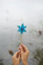 Blue pinwheel with a ladybug in the center held by teenage hands on the move for the wind. Royalty Free Stock Photo