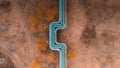 Blue pipeline over the fields. Abstract aerial view drone photo in neutral colors.