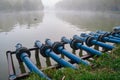 Blue pipes connected into a city pond, on a foggy morning, at Alexandru Ioan Cuza IOR park, Bucharest, Romania