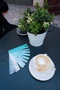 Blue planks menu with various drinks names and cup of coffee on blue table