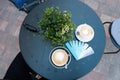 Blue planks menu with various drinks names and cups of coffee on blue table