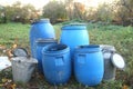 The blue plastic barrels for storage of chemicals . Stockpile of used blue plastic drums for storing water and other liquids