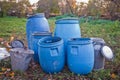 The blue plastic barrels for storage of chemicals . Stockpile of used blue plastic drums for storing water and other liquids.