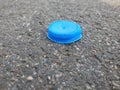 Blue, plastic bottle cap on the asphalt Royalty Free Stock Photo