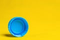 Blue plastic bottle cap on yellow background Royalty Free Stock Photo