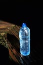 A blue plastic bottle with spring water from near an old well Royalty Free Stock Photo