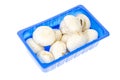Blue plastic box with fresh champignons isolated on white Royalty Free Stock Photo