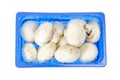 Blue plastic box with fresh champignons isolated on white Royalty Free Stock Photo