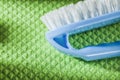 Blue plastic brush on green dishrag Royalty Free Stock Photo