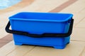 Blue plastic bucket sitting outdoors on concrete patio. Royalty Free Stock Photo