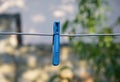 blue plastic clothespin hanging on a metal wire