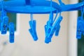 Blue plastic clothespins hanging with hanging pegs on background Royalty Free Stock Photo