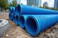 Blue plastic corrugated pipes stacked on ground for drainage system installation. Large diameter sewer conduits for construction, Royalty Free Stock Photo