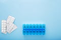 Blue plastic 14 day pill box with pills on blue background. Top view Royalty Free Stock Photo