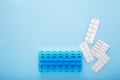 Blue plastic 14 day pill box with pills on blue background. Top view Royalty Free Stock Photo