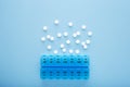 Blue plastic 14 day pill box with pills on blue background. Top view Royalty Free Stock Photo