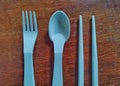 blue plastic fork,chopsticks,and spoon on wooden background Royalty Free Stock Photo