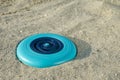 Blue plastic frisbee disc on sandy beach