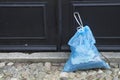 Blue plastic garbage bag in front of door Royalty Free Stock Photo