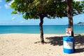 Blue plastic garbage trash can with warning board, do not litter, on a romantic sandy beach. Royalty Free Stock Photo
