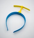 Blue plastic hair band with yellow fan propeller isolated on white Royalty Free Stock Photo