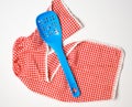 blue plastic kitchen spoon lies on a red-white kitchen towel Royalty Free Stock Photo