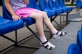 Blue plastic seats with the lower part of a little girl`s body sitting Royalty Free Stock Photo