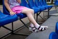 Blue plastic seats with the lower part of a little girl`s body sitting Royalty Free Stock Photo
