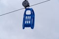 Blue plastic sled is hanging on a toboggan lift Royalty Free Stock Photo