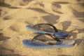 Blue plastic thongs in the sand Royalty Free Stock Photo