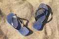 Blue plastic thongs in the sand Royalty Free Stock Photo