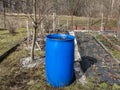 Blue, plastic water barrel prepared to be reused for collecting and storing rainwater for watering plants