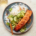 a blue plate with salmon and some rice with chopsticks