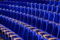 Blue plush chairs with wooden armrests in the auditorium. Empty auditorium in the theater