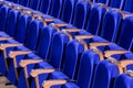 Blue plush chairs with wooden armrests in the auditorium. Empty auditorium in the theater