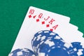 Blue poker chips lay on a combination of cards on a green table background Royalty Free Stock Photo