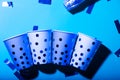 Blue polka dot paper cups and straws in ultraviolet light Royalty Free Stock Photo