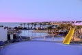 Blue pool at sunrise or sunset with a yellow slide. View from the hill, a beautiful place to relax in a five star Egypt hotel.