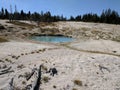 Blue pool with tiny stream leading to it at Yellowstone National Park