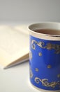 Blue porcelain china cup with tea, open book and white background Royalty Free Stock Photo