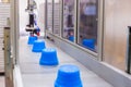 Blue pots on conveyor belt of plastic injection molding machine with robotic arm