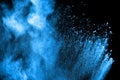 Blue powder explode cloud on black background. Launched blue dust particles splash on background