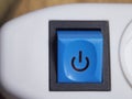 Blue power button on white extension cable. Power button, close-up shot Royalty Free Stock Photo
