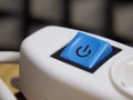 Blue power button on white extension cable. Power button, close-up shot Royalty Free Stock Photo